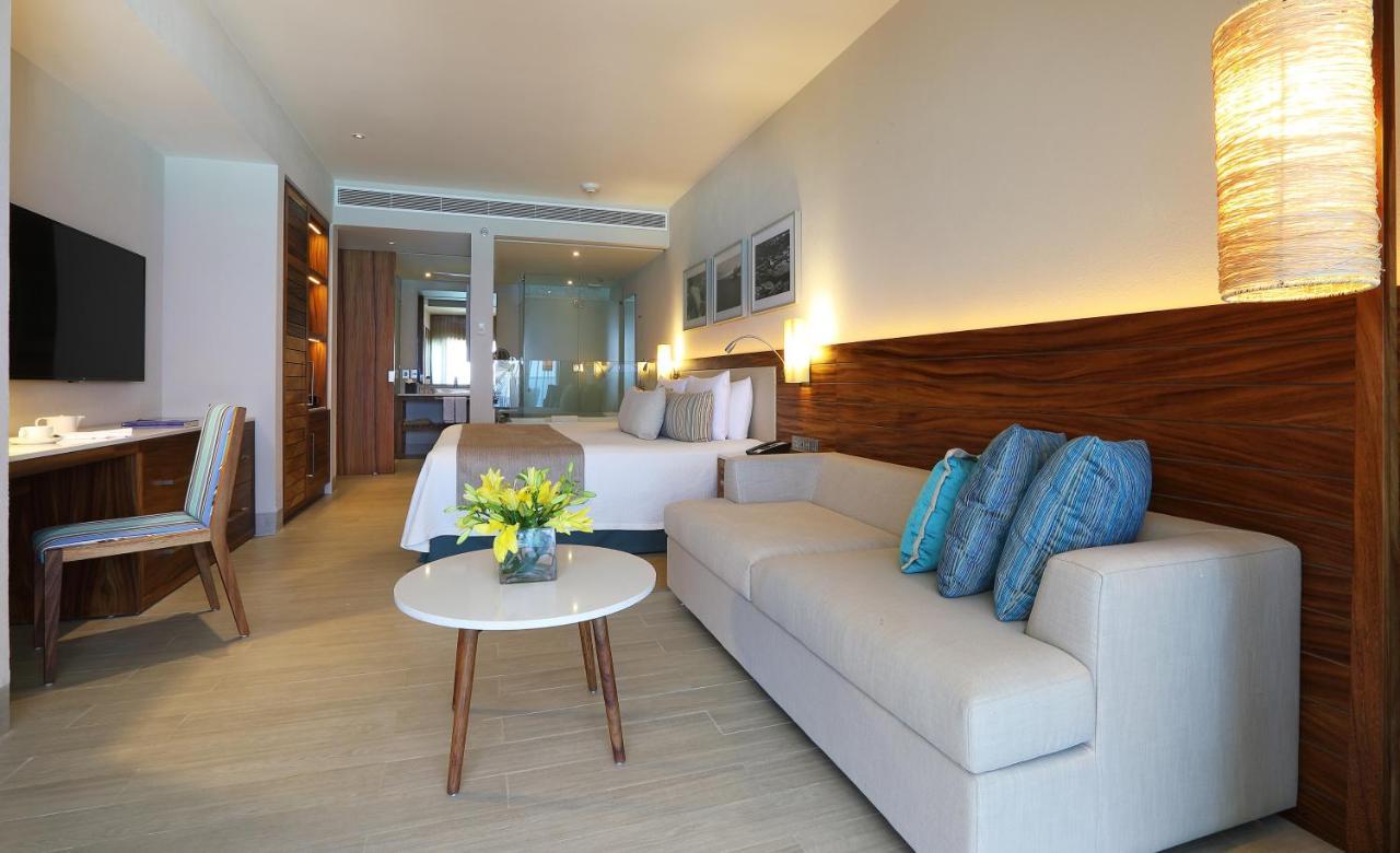 Suíte deluxe com cama king-size e vista parcial do mar